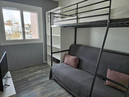 - un salon avec un canapé et des lits superposés dans l'établissement Appartement rénové au pied des pistes avec balcon et parking - FR-1-417-26, à La Toussuire