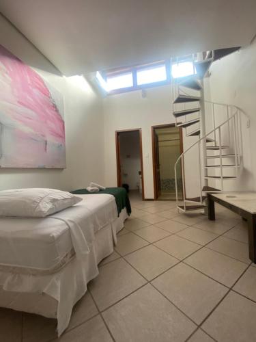 a bedroom with a bed and a spiral staircase at GH Bizkaia in Florianópolis