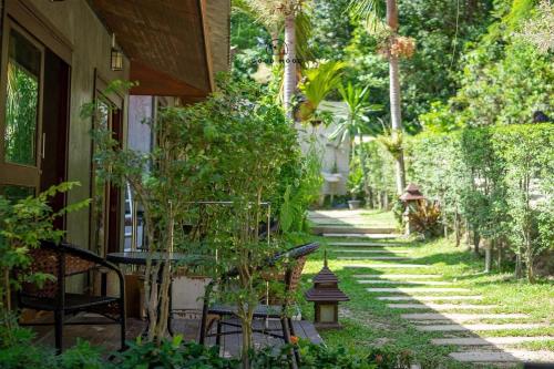 ein Garten mit Stühlen und einem Weg neben einem Haus in der Unterkunft Good Mood Resort in Ko Lipe