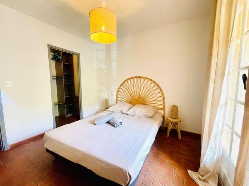 une chambre avec un grand lit avec une tête de lit en bois dans l'établissement L'Etoile du Port de St Aygulf, à Fréjus