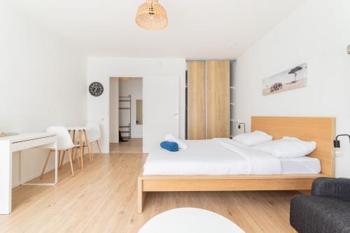 une chambre blanche avec un lit et un bureau dans l'établissement Appartement cosy au cœur de Lille - Euralille, à Lille
