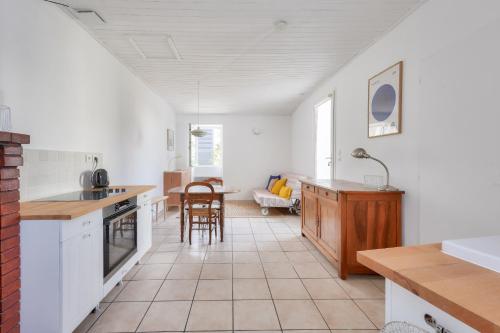 une cuisine avec des armoires blanches et une table et des chaises dans l'établissement Sejour calme, 1,5 km de la plage de la Terriere, à La Tranche-sur-Mer