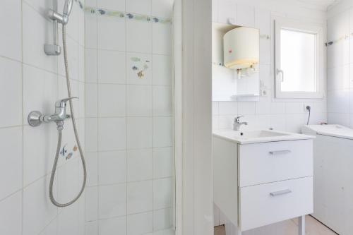 une salle de bain blanche avec une douche et un lavabo dans l'établissement Sejour calme, 1,5 km de la plage de la Terriere, à La Tranche-sur-Mer
