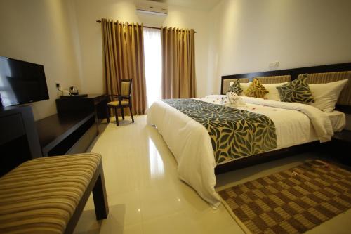 a hotel room with a bed and a television at Ruins Chaaya Hotel in Polonnaruwa
