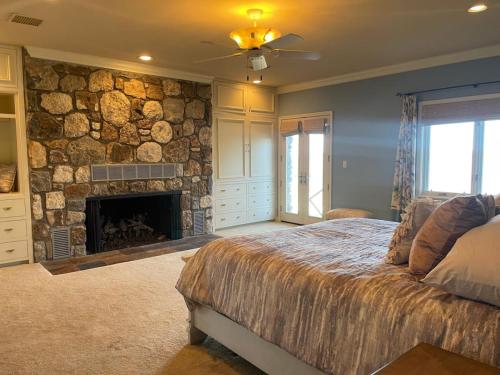 a bedroom with a stone wall with a bed and a fireplace at The Lodge at Stony Point in Jay
