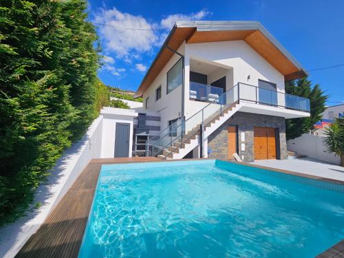 a villa with a swimming pool in front of a house at Vistadouro 3 Style in Peso da Régua