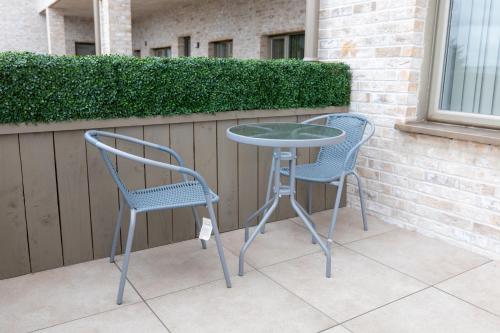 zwei Stühle und ein Tisch auf einer Terrasse in der Unterkunft Centrally Located 2Bed Flat With Balcony & Parking in Cardiff