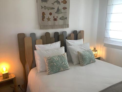 une chambre avec un lit avec des oreillers blancs dans l'établissement Scidesdunes, à Merville-Franceville-Plage