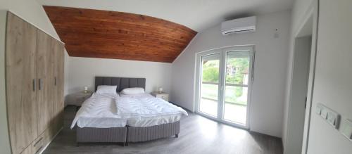 a bedroom with a bed and a large window at Meem in Konjic