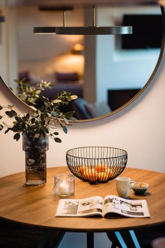 a table with a mirror and a book on it at Landgoed Moerslag in Sint Geertruid