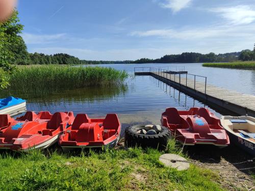 a group of boats parked next to a dock at Ostoja Becejły in Szypliszki