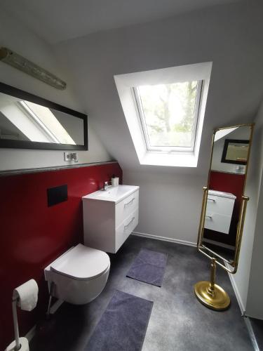 a bathroom with a toilet and a sink and a window at Haus Laila in Heidesee