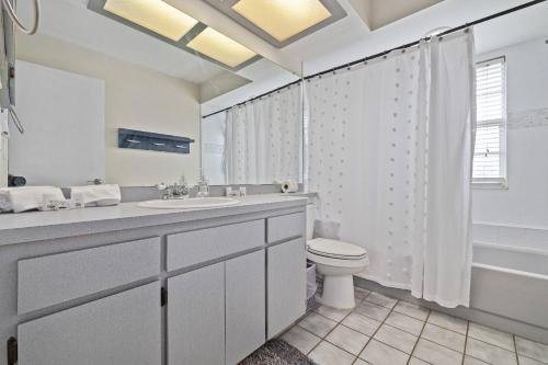 ein weißes Badezimmer mit Waschbecken und Toilette in der Unterkunft Sunshine and Serenity in Palm Harbor