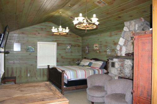 a bedroom with a bed in a log cabin at Stony Point Gated Resort in Jay