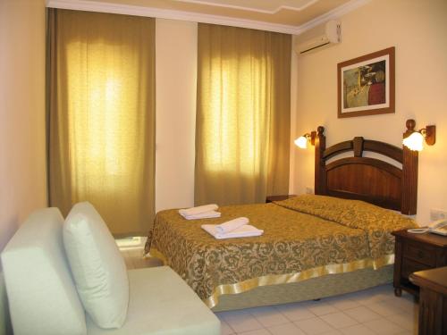 a hotel room with a bed and a couch at Hotel Bağevleri in Gümbet