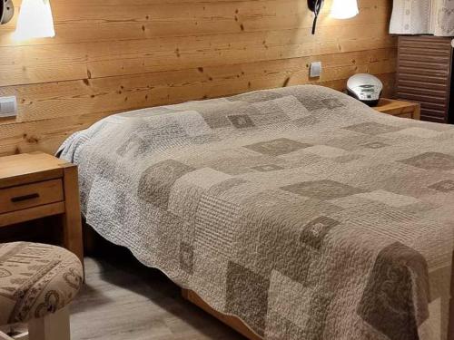une chambre avec un lit et un mur en bois dans l'établissement Bel appartement rénové 5 personnes, Croisette, au pied des pistes, avec wifi et balcon - FR-1-574-14, aux Menuires