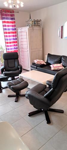 une chambre avec deux chaises, une table et des chaises dans l'établissement Patio sur garrigue, à Saint Pierre La Mer