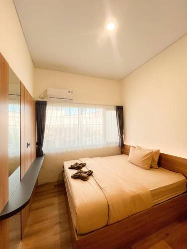 una camera da letto con un letto con le scarpe sopra di Villa Kamar Tamu Maleha a Gandok