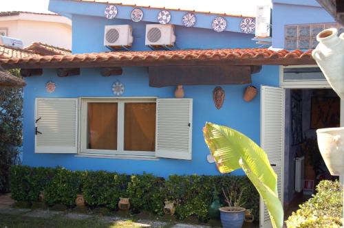 フレジェネにあるB&B Sinbad La Scialuppaの白いシャッターと窓のある青い家