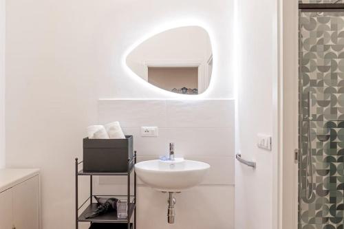 a white bathroom with a sink and a mirror at 5 minuti dal porto CityAndSea in Livorno