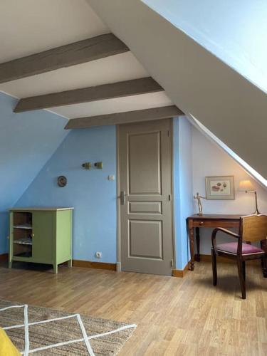 Cette chambre mansardée dispose d'une table et d'un escalier. dans l'établissement Gîtes l'appel de la Bretagne Gîte Bleuenn, à Lannion