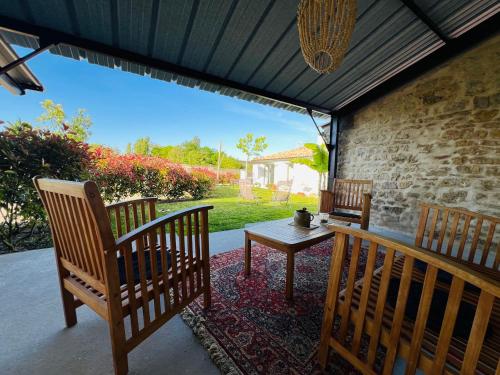 d'une terrasse avec 2 chaises et une table en bois. dans l'établissement Gîte de caractère à moins de 10min des plages, à Saint-Michel-en-lʼHerm