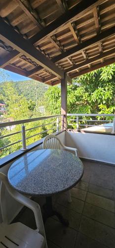 a table and chairs on a balcony with a view at GH Bizkaia in Florianópolis