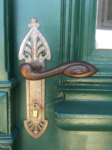 a bronze door knocker on a green door at Altes Pastorat in Barmstedt