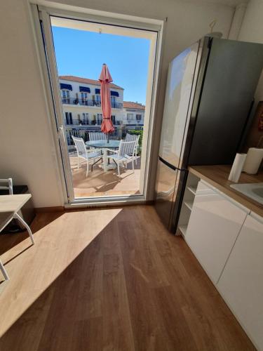 une cuisine avec une porte coulissante en verre menant à une terrasse. dans l'établissement Vacances en Camargue, au Grau-du-Roi