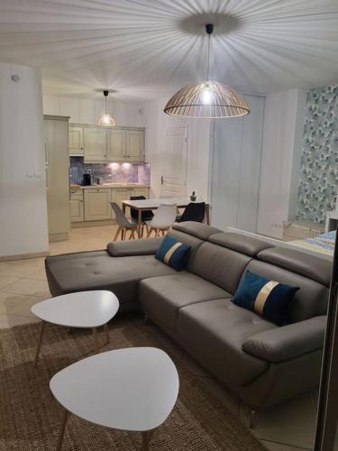 Il comprend un salon avec un canapé et des tables ainsi qu'une cuisine. dans l'établissement Magnifique appartement en centre-ville av parking, à Cavalaire-sur-Mer