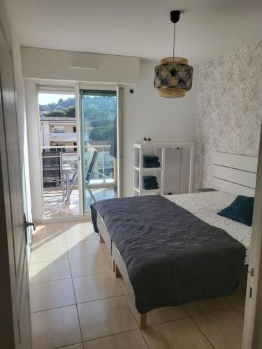une chambre avec un lit et un balcon dans l'établissement Magnifique appartement en centre-ville av parking, à Cavalaire-sur-Mer