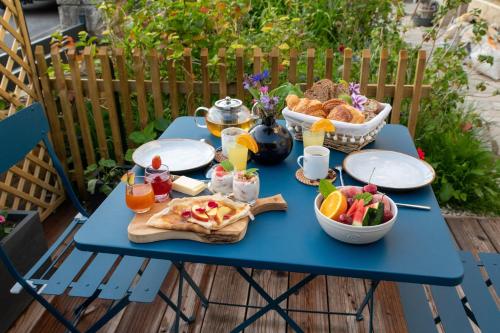 ein blauer Tisch mit Essen und Obst darauf in der Unterkunft L'Escale Fleurie à Saint Brieuc in Saint-Brieuc