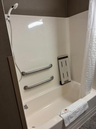 a bathroom with a bath tub with a light and towels at Comfort Inn Huntington near University area in Huntington