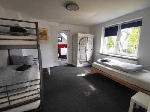 a bedroom with two bunk beds and two windows at Haus Laila in Heidesee