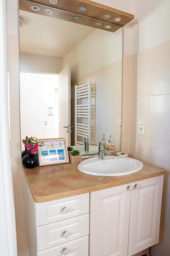 La salle de bains est pourvue d'un lavabo et d'un comptoir avec une fenêtre. dans l'établissement L'Escale Fleurie à Saint Brieuc, à Saint-Brieuc