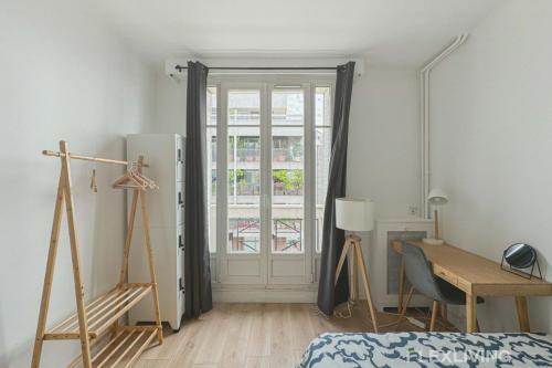 Cette chambre comprend un lit, un bureau et une porte. dans l'établissement Flexliving - room - Houel, à Paris
