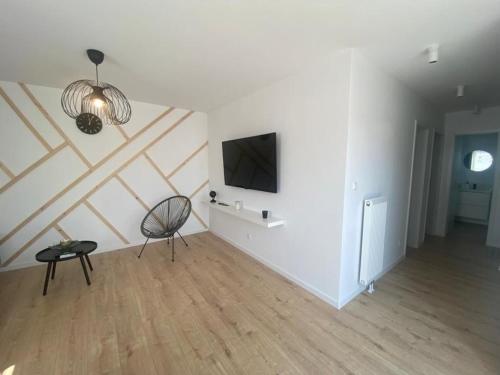 a living room with a television and a chair at Ferienhaus nah Ijsselmeer mit schönem sonnigem Garten in Wervershoof