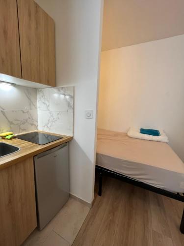 Cette petite chambre comprend un lit et un lavabo. dans l'établissement Dream Dwell Paris - Flat 800m to Champs de Mars, à Paris