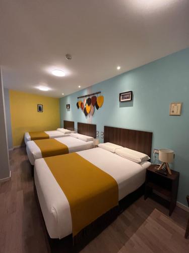 a group of four beds in a room at CASA CRISTOBAL Centenario in Cusco