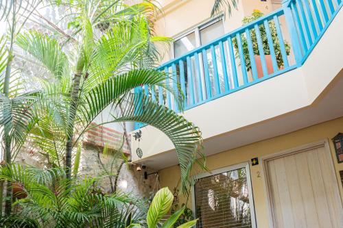 a house with a blue balcony and a palm tree at Posada La Fe in Cartagena de Indias