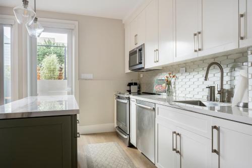 a kitchen with white cabinets and stainless steel appliances at Modern Luxury 3 BR Near Presidio & GG Park in San Francisco