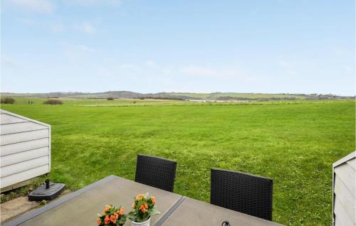 a table and chairs with a large field in the background at Gorgeous Apartment In Lemvig in Lemvig