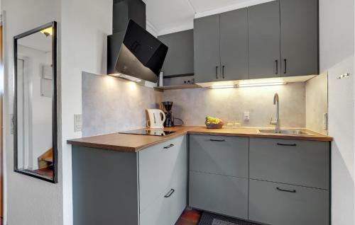a kitchen with white cabinets and a sink and a mirror at Gorgeous Apartment In Lemvig in Lemvig
