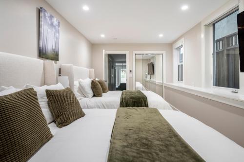 two white beds in a room with windows at Modern Luxury 3 BR Near Presidio & GG Park in San Francisco
