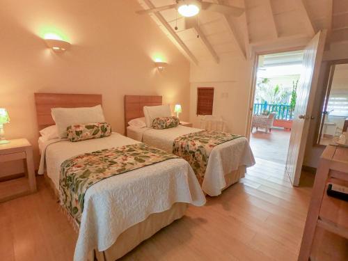 a hotel room with two beds and a balcony at Posada La Fe in Cartagena de Indias