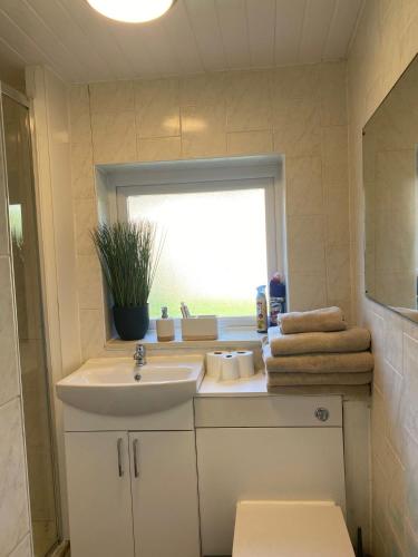 a bathroom with a sink and a window at Prettide Suite - Free Parking in Gillingham