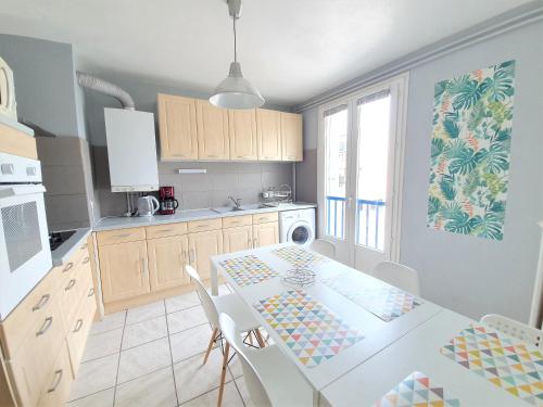une cuisine avec une table blanche et une table et des chaises dans l'établissement Appartement dans résidence calme, à Montpellier
