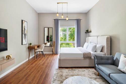 a bedroom with a bed and a couch at Chic studio near metro at Discovery Gardens in Dubai