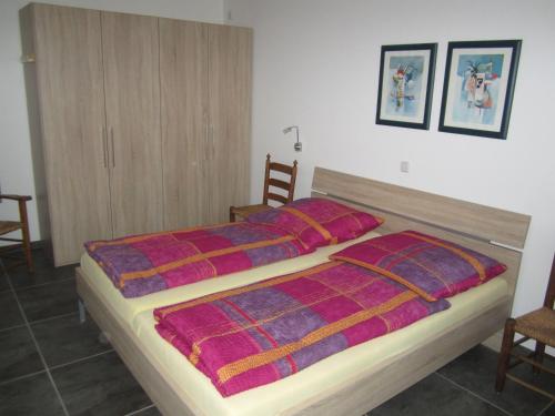 クサンテンにあるFerienwohnung Mauritiusstraßeのベッドルーム1室(カラフルな毛布付きのベッド1台付)