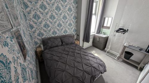 a bedroom with a bed in a room with wallpaper at Martell's Hotel in Blackpool